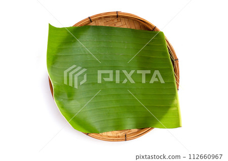 Banana leaves in bamboo weave plate on white background. Banana leaves in bamboo weave plate on white background. 112660967