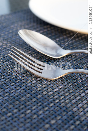 Spoon and fork on place mat 112661034