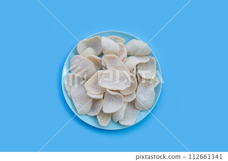 Prawn crackers on blue background. Shrimp crispy rice snack 112661341