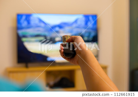 Hand holding TV remote control Hand holding TV remote control 112661915