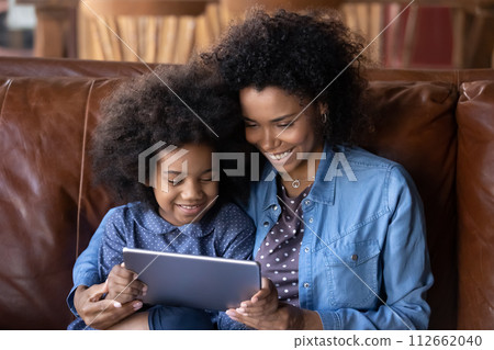 African mother her little daughter having fun using digital tablet African mother her little daughter having fun using digital tablet 112662040