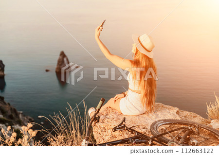 Selfie woman in cap and tank top making selfie shot mobile phone post photo social network outdoors on sea background beach people vacation lifestyle travel concept. 112663122