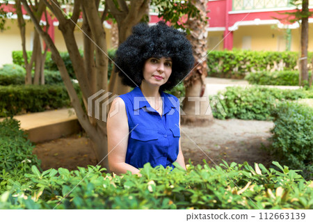 Woman about 30 years old in a blue dress portrait near a tree 112663139