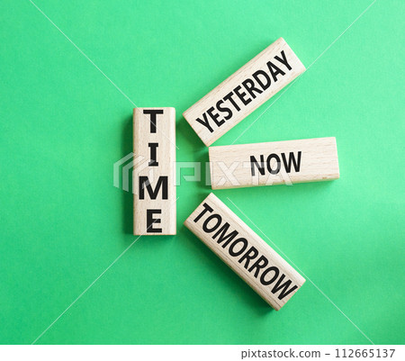 Time - Yesterday Now Tomorrow. Wooden cubes with words Time. Beautiful green background. Business and Time concept. Copy space. 112665137