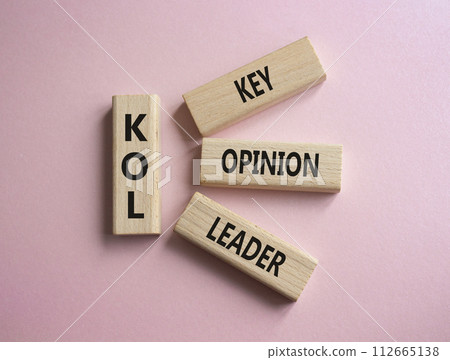 KOL - Key Opinion Leader symbol. Concept word KOL on wooden blocks. Beautiful pink background. Business and KOL concept. Copy space. 112665138