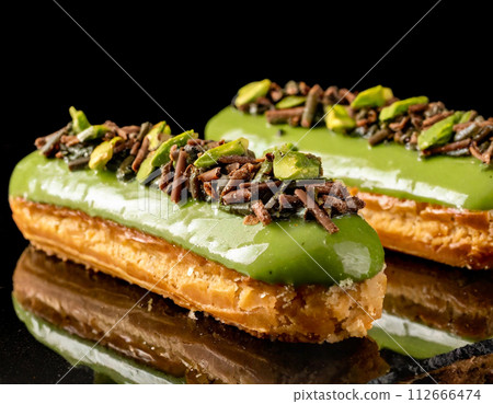 Eclairs with cacao nibs and pistachio cream 112666474