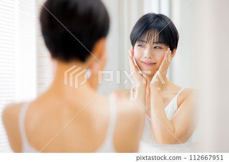 A woman doing skin care in the bathroom A woman doing skin care in the bathroom 112667951