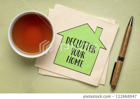 declutter your home motivational reminder - handwriting and sketch on a napkin with a cup of tea, simplicity and minimalism concept declutter your home motivational reminder - handwriting and sketch on a napkin with a cup of tea, simplicity and minimalism concept 112668047