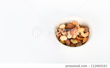 Concept, trail mix day. trail mix In a cup placed on a white floor table. Closeup. copy space on left for design or text. White background. 112669161