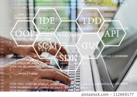 Abbreviations that every programmer should know, such as OOP, SCM, VCS, WYSIWYG, GUI, API, IDE, TDD, SDK. Programmers sit and write programs with their laptop computers. Close up, Blurred background 112669177