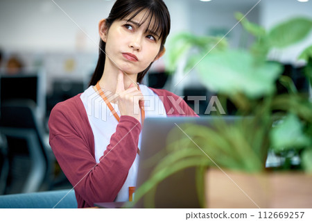 Business woman working at a desk in a bright office Business woman working at a desk in a bright office 112669257