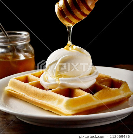 The moment when honey is poured onto a waffle with vanilla ice cream 112669486