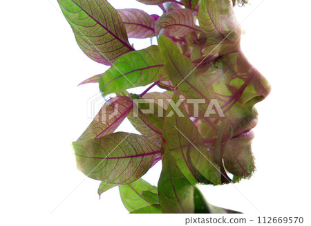 An artistic double exposure portrait of a man's profile with leafy elements 112669570