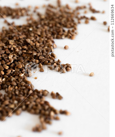 A Pile Of Brown Grains of buckwheat On A White Surface 112669634