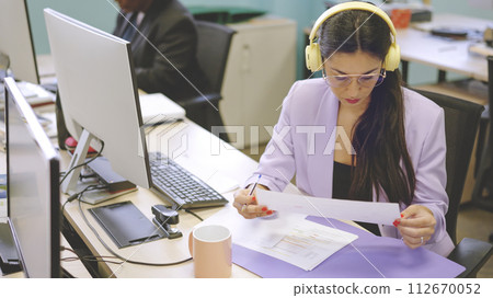 Concentrated woman reading a financial report in a coworking 112670052