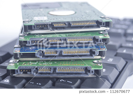 2.5-inch hard drive, swivel plate and keyboard keys put on a white background 2.5-inch hard drive, swivel plate and keyboard keys put on a white background 112670677