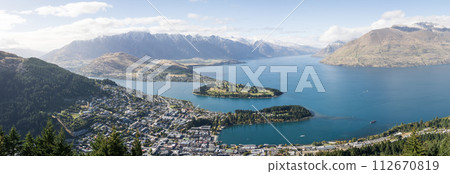 Wide panoramic view on mountain town on a lake shore surrounded by beautiful mountains, New Zealand Wide panoramic view on mountain town on a lake shore surrounded by beautiful mountains, New Zealand 112670819
