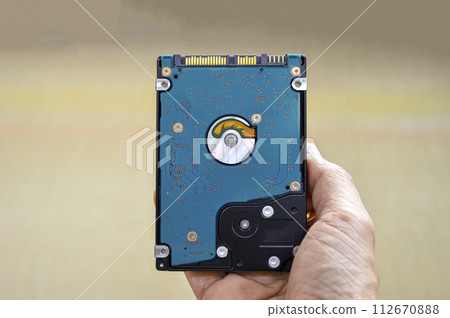 Hand holding 2.5 inch hard drive, swivel plate type It is still commonly used today 112670888