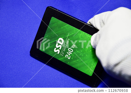 2.5 inch SSD hard drive laid on a blue background. 112670938