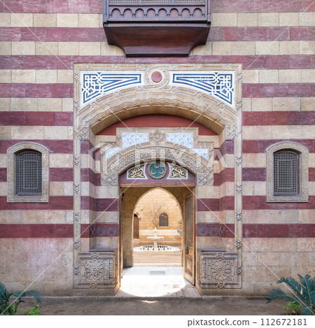 Striking red and white striped arched entrance leads into a Mamluk era style building Striking red and white striped arched entrance leads into a Mamluk era style building 112672181