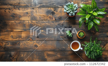 Cup of tea and houseplants on a wooden background. 112672342