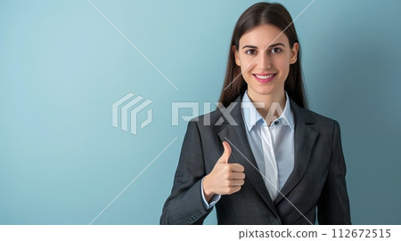 Portrait of a beautiful business woman showing thumbs up on blue background 112672515
