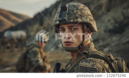 A Caucasian man in a camouflage military uniform is on a battlefield full of troops. 112673240