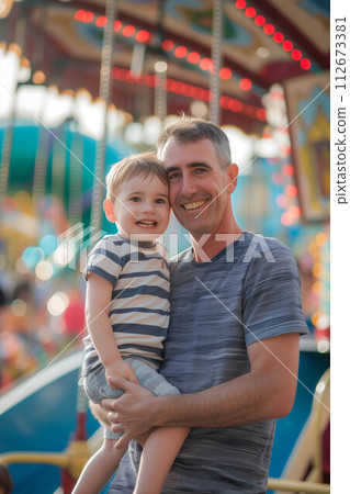 Caucasian father holding son in amusement park. 112673381
