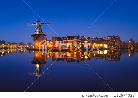 The windmill De Adriaan, Haarlem, Netherlands. Historic buildings. Cityscape during the blue hour. The windmill De Adriaan, Haarlem, Netherlands. Historic buildings. Cityscape during the blue hour. 112674028