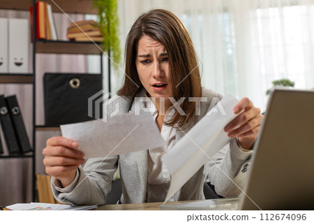 Businesswoman girl opening envelope reading bad news in letter feels upset bankruptcy at home office Businesswoman girl opening envelope reading bad news in letter feels upset bankruptcy at home office 112674096