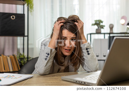 Tired sleepy young businesswoman sitting at home office desk with laptop overworked lazy bored Tired sleepy young businesswoman sitting at home office desk with laptop overworked lazy bored 112674108