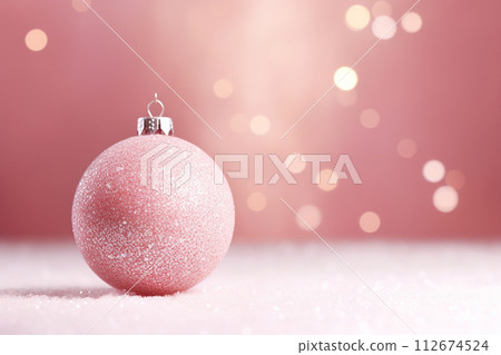 Christmas bauble pink on pink background with warm bokeh lights Christmas bauble pink on pink background with warm bokeh lights 112674524