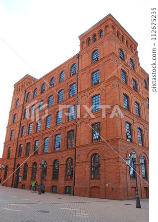 Facade of red brick factory building. Old factory in Lodz 112675235
