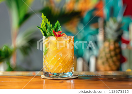 mai tai cocktail with pine apple and palm tree leaves on background 112675315