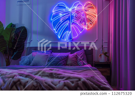 Neon sign monstera in decor of bedroom in modern apartment 112675320