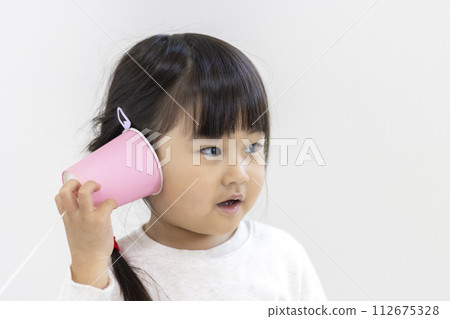 Girl playing with a string phone (3 years old, Japanese) Girl playing with a string phone (3 years old, Japanese) 112675328