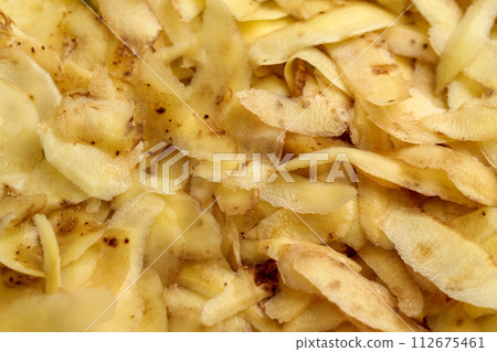Heap of fresh potato peels. Peeled vegetable skin. Kitchen garbage. Abstract food background. Organic recycling concept 112675461