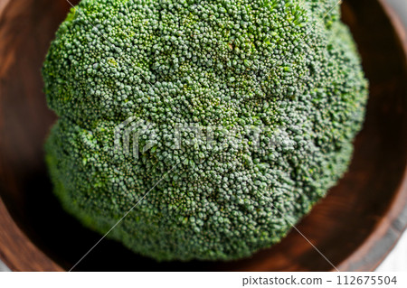 Pieces of fresh organic Broccoli in rustic bowl. Farm fresh vegetables. Green plant bio texture. Pieces of fresh organic Broccoli in rustic bowl. Farm fresh vegetables. Green plant bio texture. 112675504
