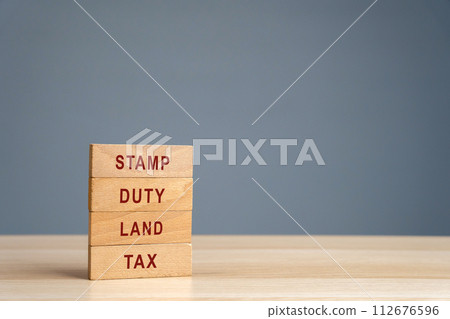 Stamp duty land tax SDLT concept. Taxes assessed during the transfer of real estate between two parties. Buying housing and land. Property. Wooden blocks 112676596