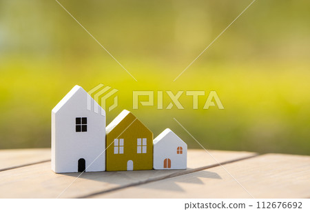 Wooden houses stand in a row outdoors on a sunny day. Real estate and affordable housing concept. Mortgage, loan. Eco-friendly house 112676692