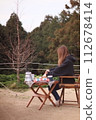 Foreign woman sitting on an outdoor chair at a campsite 112678414