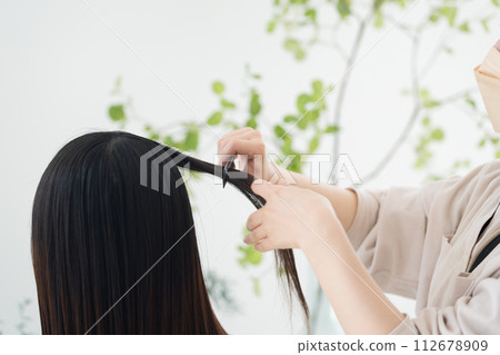 Close-up of hair setting, cutting, coloring, etc. at a beauty salon, without face 112678909