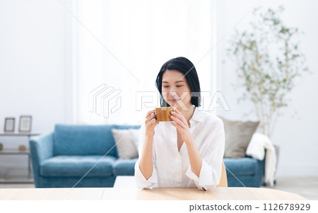 年輕女子在客廳裡喝咖啡 112678929