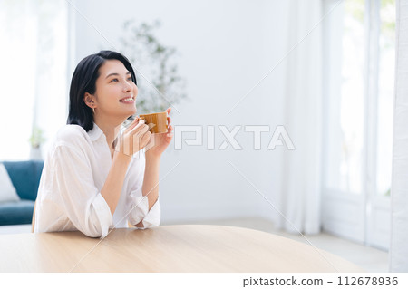 一個女人在一個房間裡喝咖啡 112678936