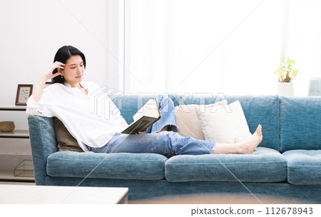 年輕女子在客廳放鬆時讀書 112678943