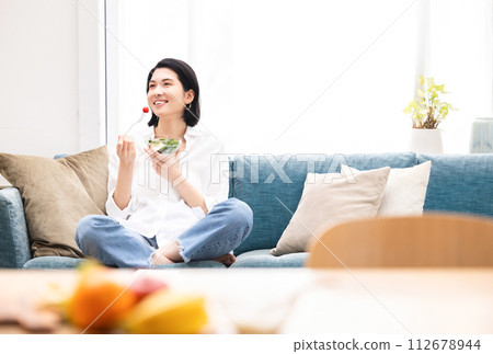 A young woman eating a salad A young woman eating a salad 112678944