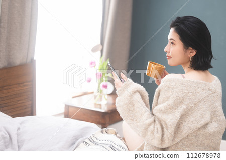 Woman drinking coffee in bed 112678978