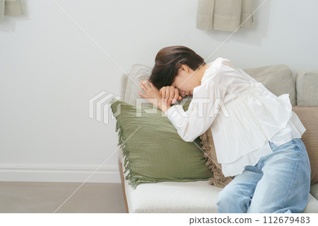 A woman who is feeling exhausted due to poor health A woman who is feeling exhausted due to poor health 112679483
