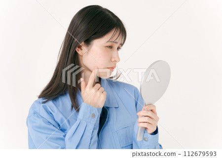 A woman in work clothes checking her skin 112679593