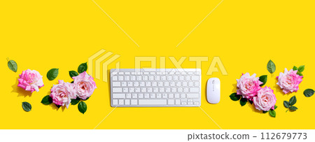 Computer keyboard and a mouse with pink roses 112679773